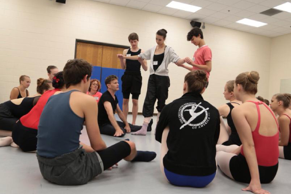 A group of dancers sitting on the ground