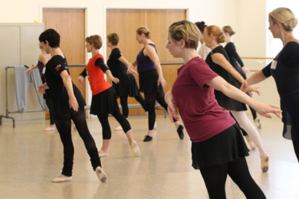 A group of people leaning forward in a ballet position