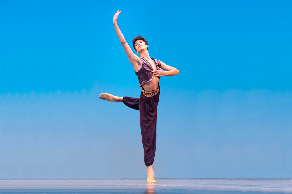 Man in a ballet position with hand in the air Man in a ballet position with hand in the air