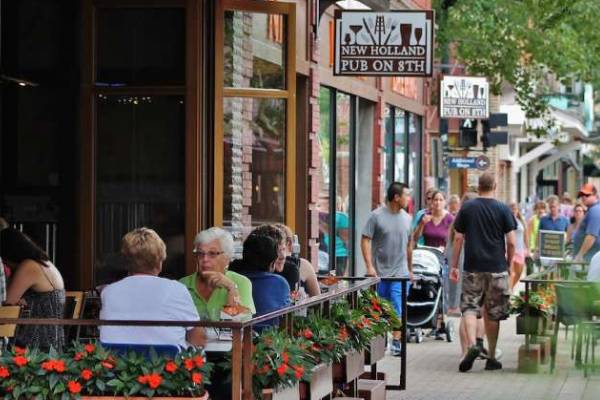 An outdoor seating area of a pub with people walking past