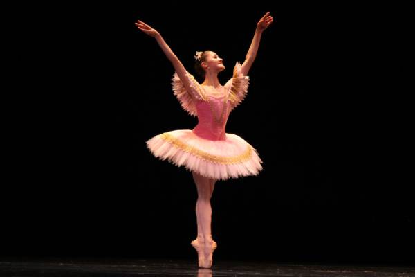 Woman in a ballet position with her arms in the air